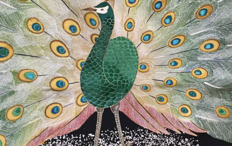 深緑の孔雀と扇状に広がる尾羽を金銀糸で精緻に刺繍した着物柄のクローズアップ