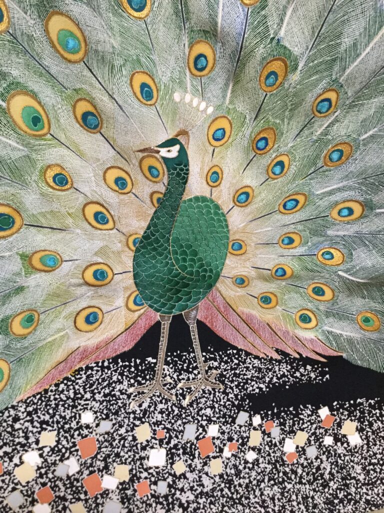深緑の孔雀と扇状に広がる尾羽を金銀糸で精緻に刺繍した着物柄のクローズアップ