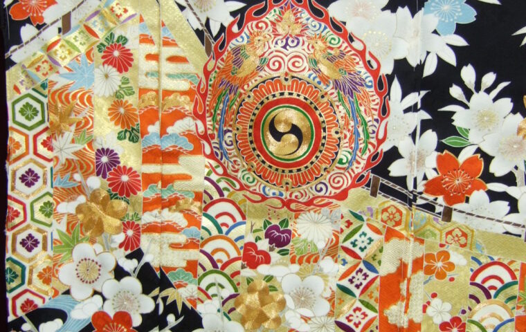 黒地に火焔太鼓・桜・梅・琴など王朝吉祥文様を金彩で密に配した黒振袖の柄アップ