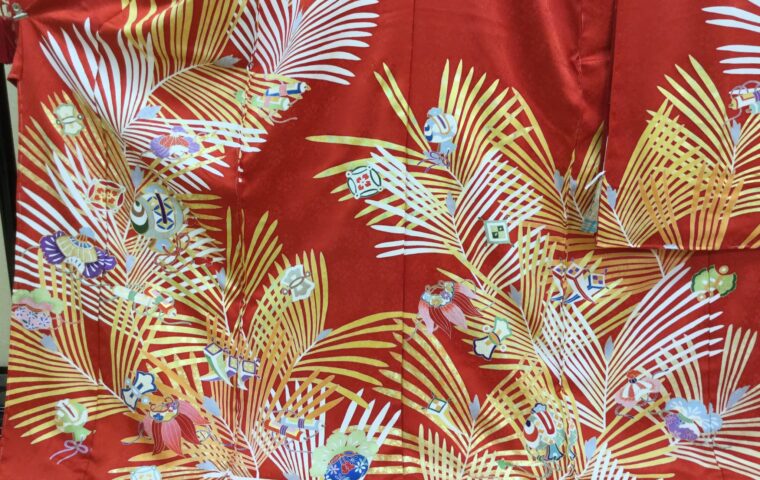 朱赤地に棕櫚の葉と手毬・独楽・花籠の御所遊び文様を配した華やかな振袖の生地アップ｜染と呉服はっとり