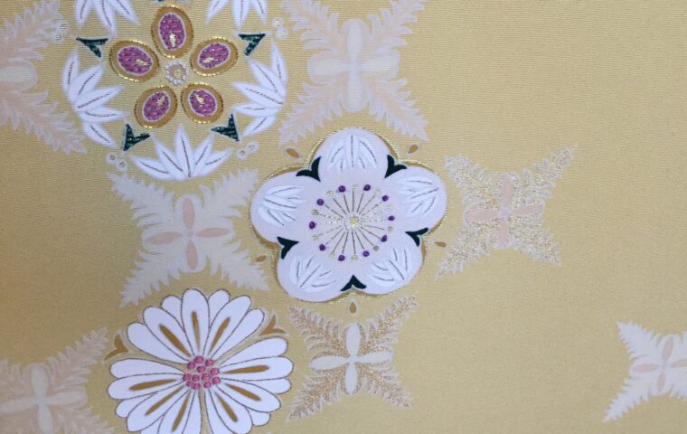 山吹色地に白刺繍の菊・梅・花丸文様が散りばめられた着物生地アップ｜染と呉服はっとり