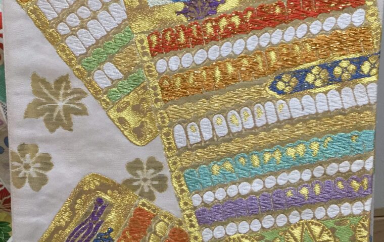 白地に金糸・色糸で短冊文様を豪華に刺繍した袋帯のアップ｜青龍・七色横段・金彩刺繍｜染と呉服はっとり
