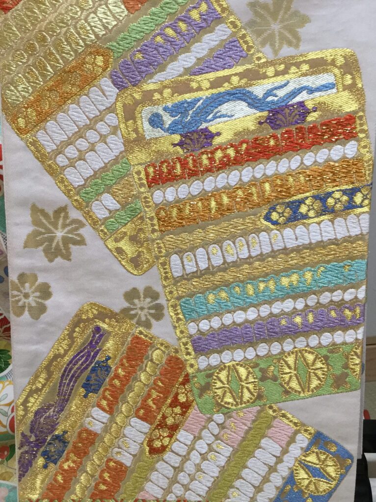 白地に金糸・色糸で短冊文様を豪華に刺繍した袋帯のアップ|青龍・七色横段・金彩刺繍|染と呉服はっとり