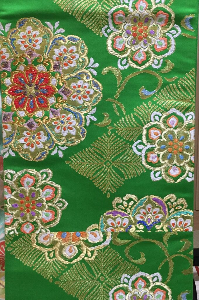 緑地に金糸・色糸で大輪の花丸文様を豪華に刺繍した振袖用袋帯のアップ｜染と呉服はっとり
